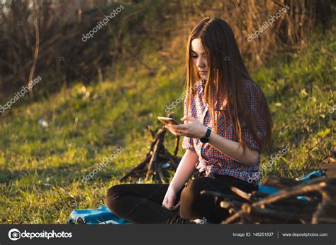 Молодая красивая девушка сидит у костра на пикнике в сумме — Стоковое