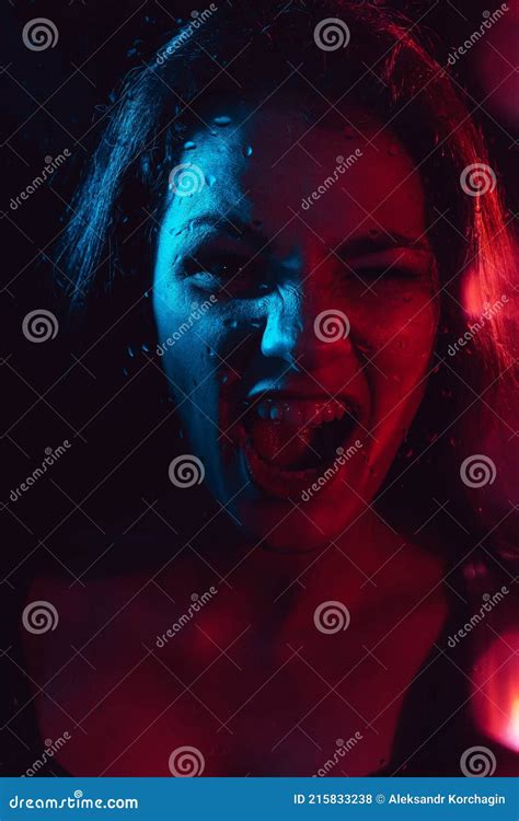 Sensual Portrait Of A Screaming Girl Behind Glass With Raindrops Stock
