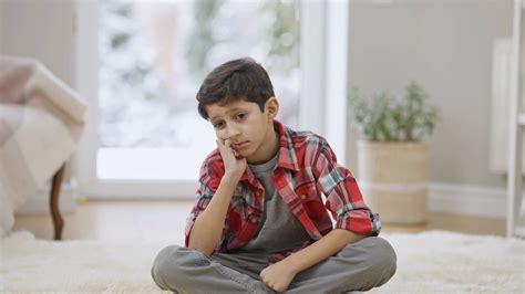 sad frustrated middle eastern boy sitting  carpet  home thinking
