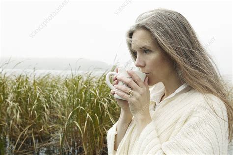 Older Woman Drinking Coffee Outdoors Stock Image F005