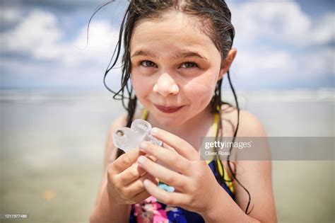 Portrait Of Girl With Wet Hair Licking Ice Cube On The Beach High Res