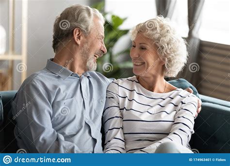 smiling mature couple relax at home hugging stock image