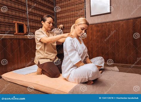 Professional Female Masseuse Massaging Her Clients Shoulders Stock