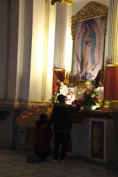 A Mother And Her Son Praying In The Our Lady Of Angels
