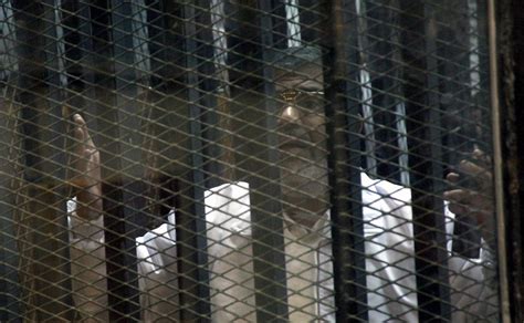 egypt locks morsi in soundproof cage during trial the new york times