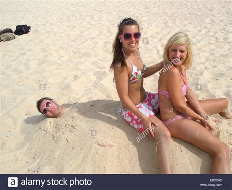 Spaß Am Strand Frauen Sitzen Auf Mann Begraben Im Sand