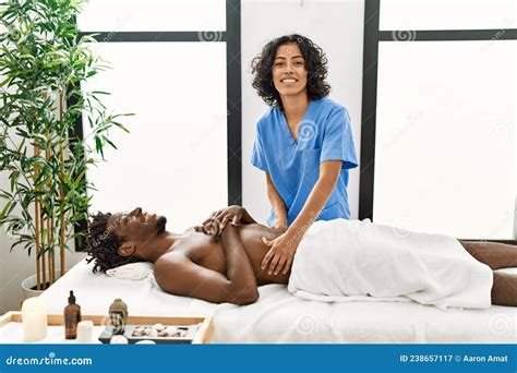 Young Physiotherapist Woman Giving Abdominal Massage To African