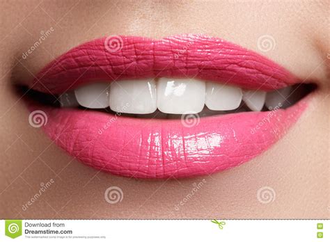 macro happy woman`s smile with healthy white teeth pink