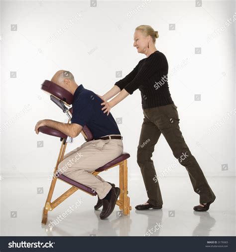 caucasian middle aged female massage therapist massaging back of