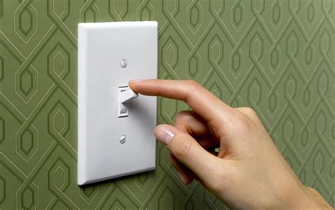 person turning   light switch  front   wallpapered green background