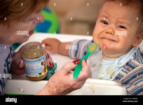 Grandmother Trying To Feed Very Unhappy Grandson Grandma Age 74 And