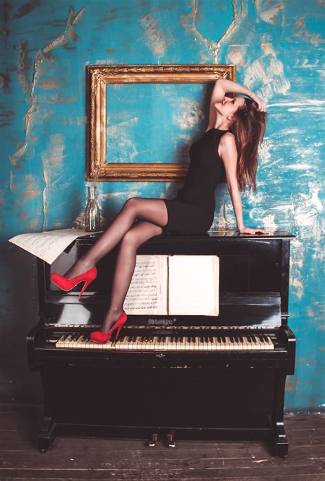 Woman Sitting On Black Wooden Upright Piano Near Rectangular Brown