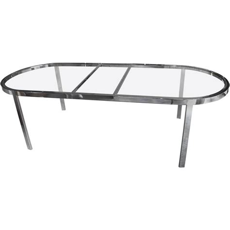An Oval Glass Table With Metal Legs On A White Background Viewed From