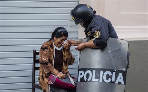 La Imagen De Un Policía Antidisturbios Que Atiende A Una Señora Se