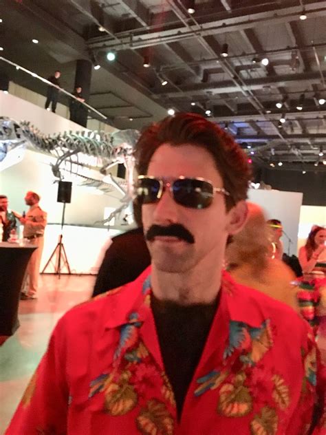 man wearing sunglasses   fake moustache stands  front   exhibit