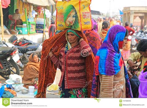 female pilgrim carrying bundle on her head on pilgrimage in india