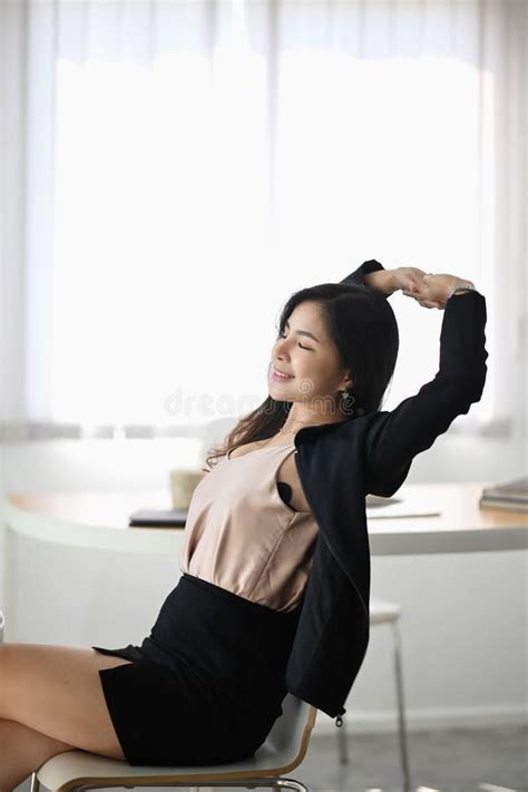 Young Female Office Worker Relaxing And Stretching Her Body At