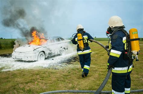 firemen spraying  flaming vehicle  stock photo