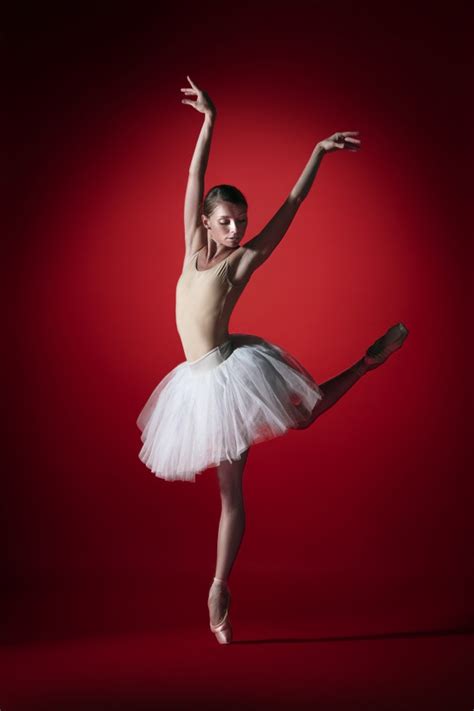 jonge sierlijke vrouwelijke balletdanser  klassieke ballerina dansen op rode studio gratis foto