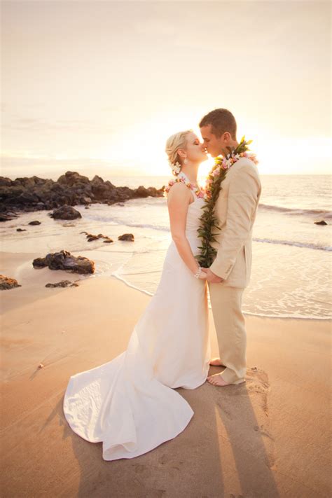 Bride And Groom Kiss On Beach With Beautiful Sunset In Back