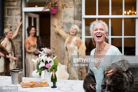 Elegant Mature Women Enjoying Champagne In Urban Garden Photo Getty