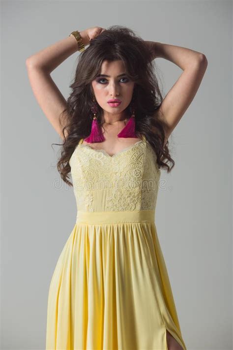 Beautiful Girl In A Long Yellow Dress On A Gray Background Stock Image
