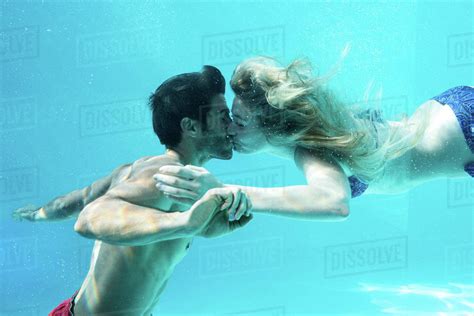 happy couple kissing underwater  swimming pool stock photo dissolve