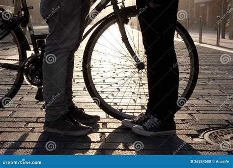 de benen van jongelui koppelen face  face aan fiets stock foto image  straat gloed