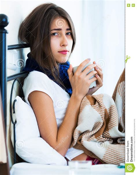 sick teenage girl with hot tea and medication indoors