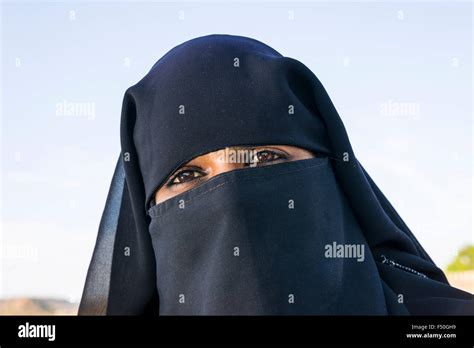 portrait   young muslim woman covering  face   black stock
