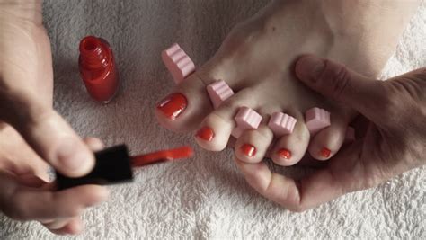 Closeup Woman Painting Nails Of Her Feet Applying Red
