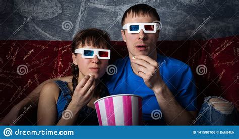 a couple of guy and girl are watching a 3d movie with