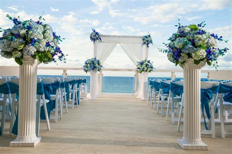 An Outdoor Wedding Set Up With Blue And White Flowers On The Aisle To