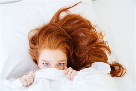 Scared Woman Lying In Bed And Hiding Under The Sheet