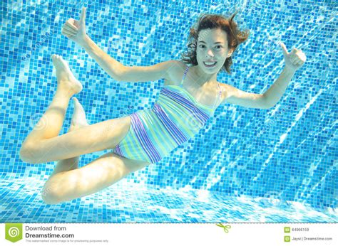 mädchen springt tauchen und schwimmen im unterwasser pool glückliches