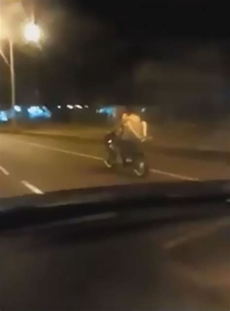 semi naked couple caught on camera having sex while riding motorbike in the middle of busy