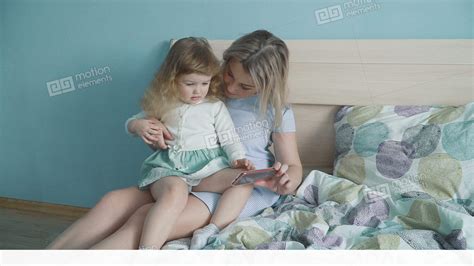 Mother And Her Cute Little Daughter Watching Video On