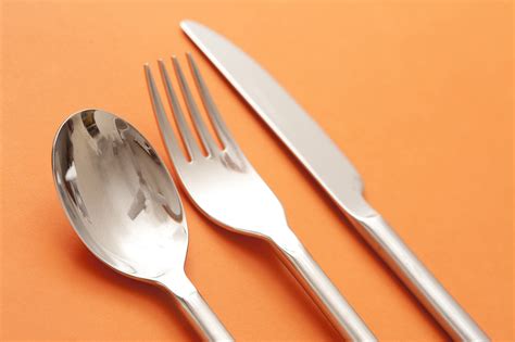 image  silver spoon fork  knife  orange background