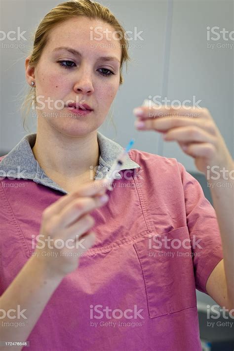 Blonde Female Nurse Prepares A Syringe For An Injection