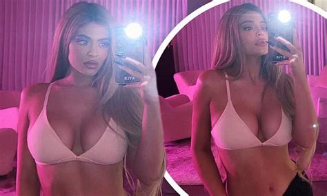 kylie jenner sizzles in a low cut nude bra while in a pink lit room as
