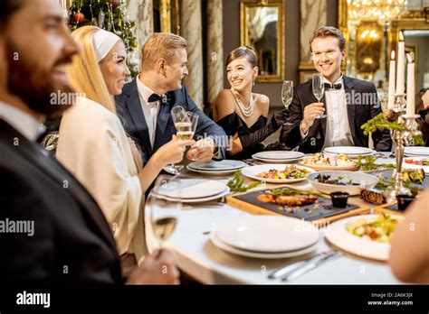 Elegantly Dressed Group Of People Having A Festive Dinner At A Well