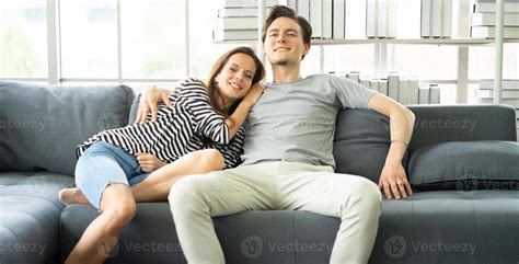 Romantic Affectionate Couple Embracing Sitting On Cozy Couch In Living