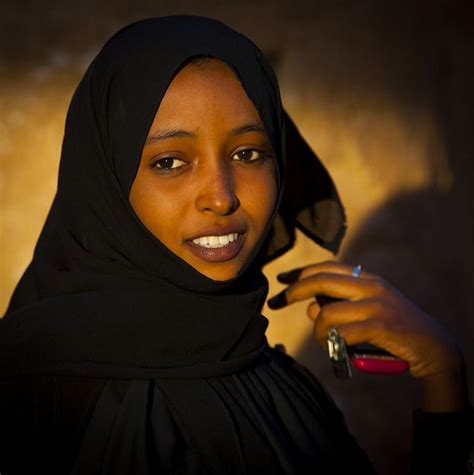 woman wearing  black hijab  holding  cell phone