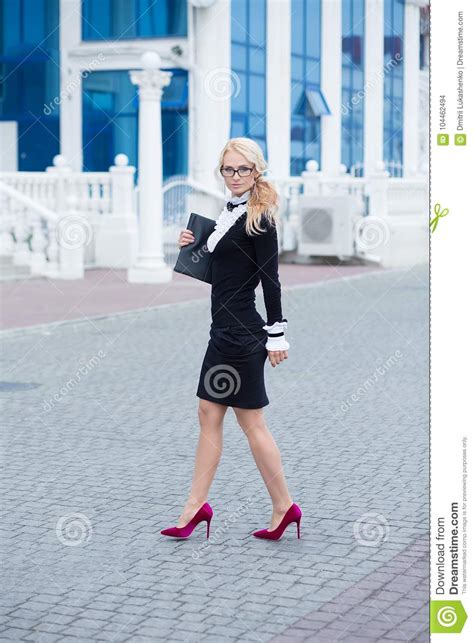 business lady woman dressed in working serious skirt and shirt posing on street with note book
