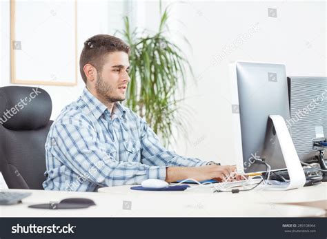 portrait  smiling young businessman typing  computer keyboard