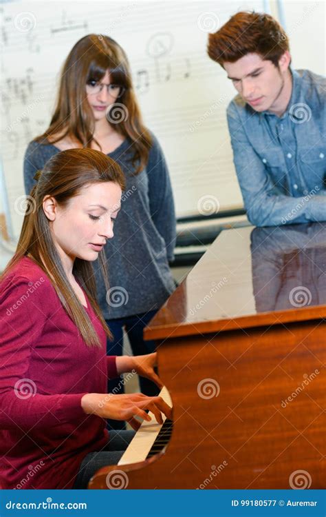 Music Teacher With Two Pupils During Piano Lesson Stock Image Image