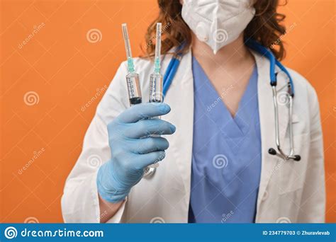 Woman Doctor Holds Syringes In His Hand On A Red Background Concept