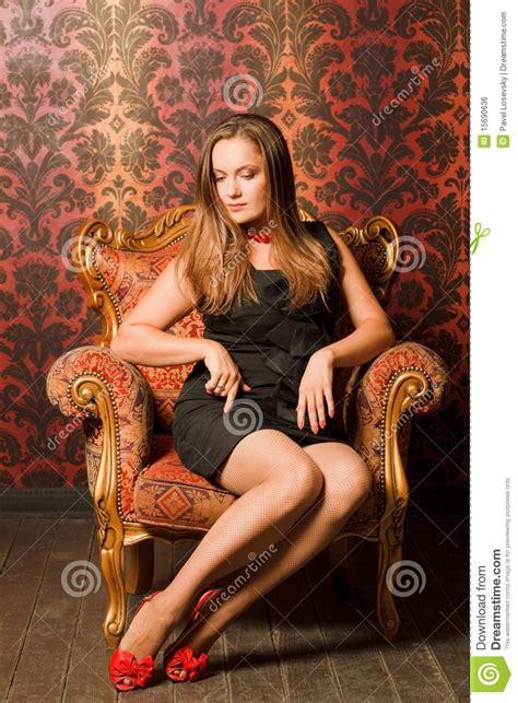 woman in red shoes and dress sitting on chair royalty free stock image