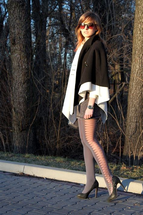 grey opaque tights with criss cross side pattern white white and black cape and heels grey