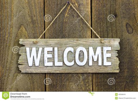 Wood Welcome Sign Hanging On Rustic Wooden Background